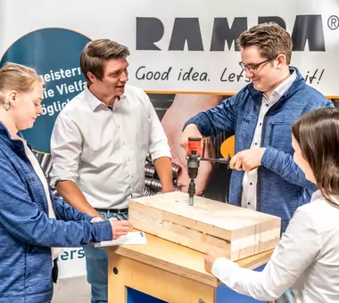 Ein RAMPA-Mitarbeiter erläutert die Verwendung unserer RAMPA-Produkte. Das Bild soll vermitteln, dass RAMPA als Hersteller Helfer und Experte in Sachen Befestigungstechnik ist und mit individuellem Rat und Tat seinen Kunden stets zur Seite steht. 