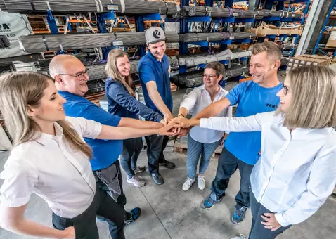 A group of RAMPA employees putting their hands on each other, symbolizing the cohesion of the RAMPA team.