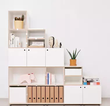 Stocubo is RAMPA's reference partner. A white cabinet with closed and open elements in a square shape including decoration can be seen. RAMPA inserts are processed in the cabinet from Stocubo.