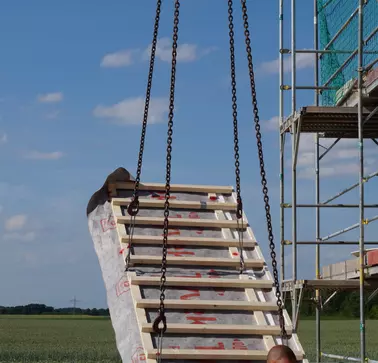 Schwabenhaus ist RAMPAs Referenzpartner. Ein schweres Holzelement wird beim Bau eines Fertighauses durch RAMPAs Muffen Typ BL sicher angehoben und bewegt. Das Holzelement wird mittels Kran angehoben.