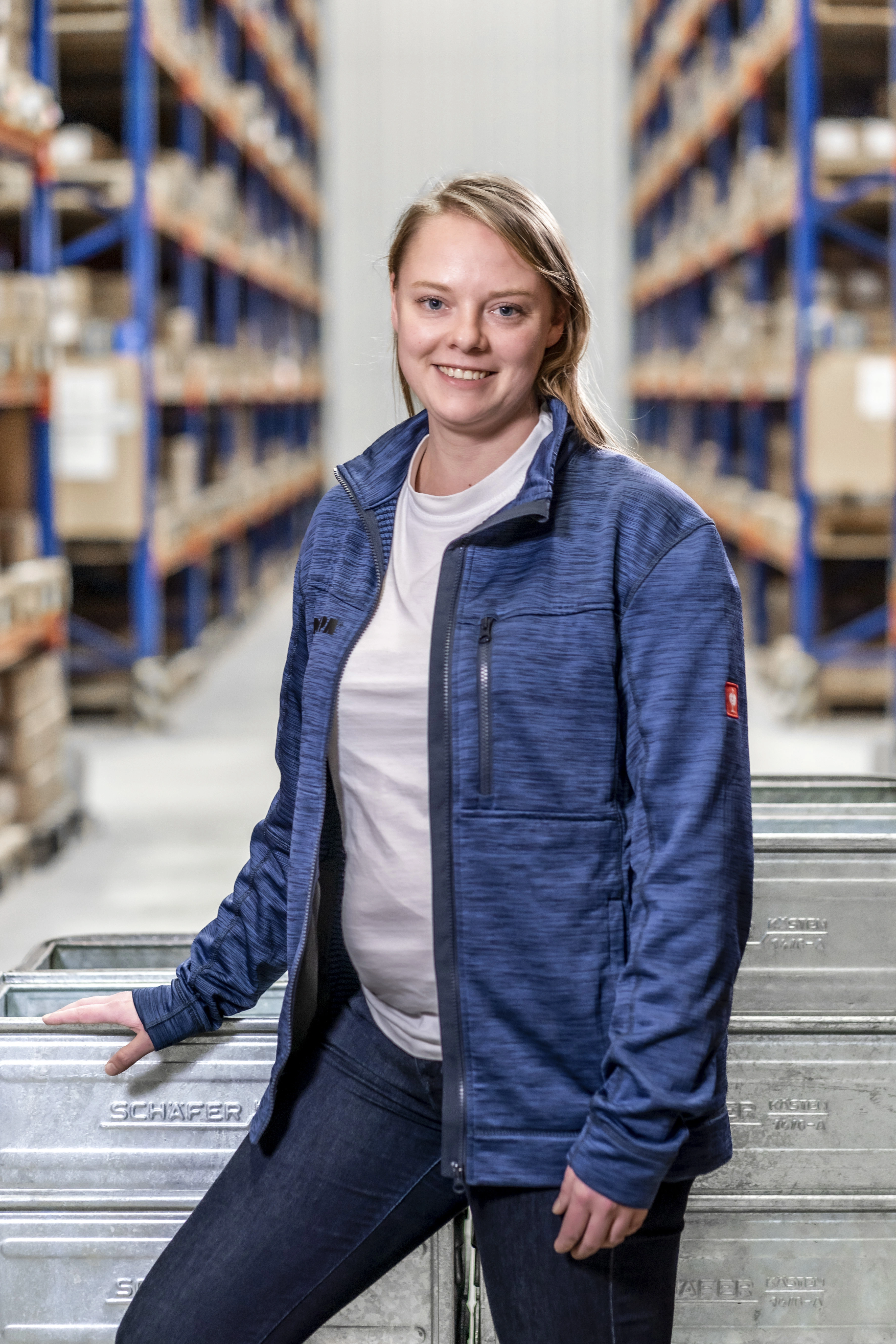 A RAMPA employee from the Shipping team standing in front of boxes full of inserts in the warehouse.