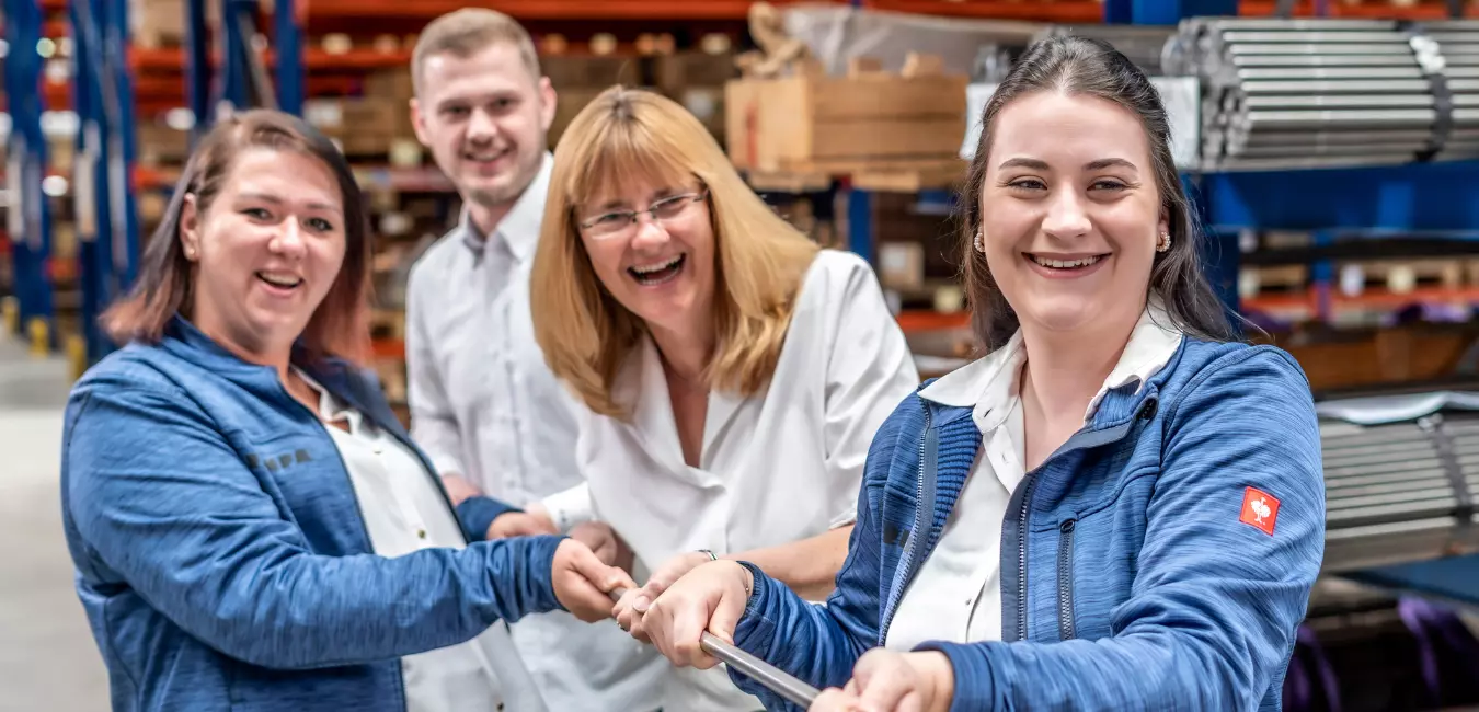 Four RAMPA employees pulling together on a threaded rod. The picture is meant to symbolize that the RAMPA team always pulls together.