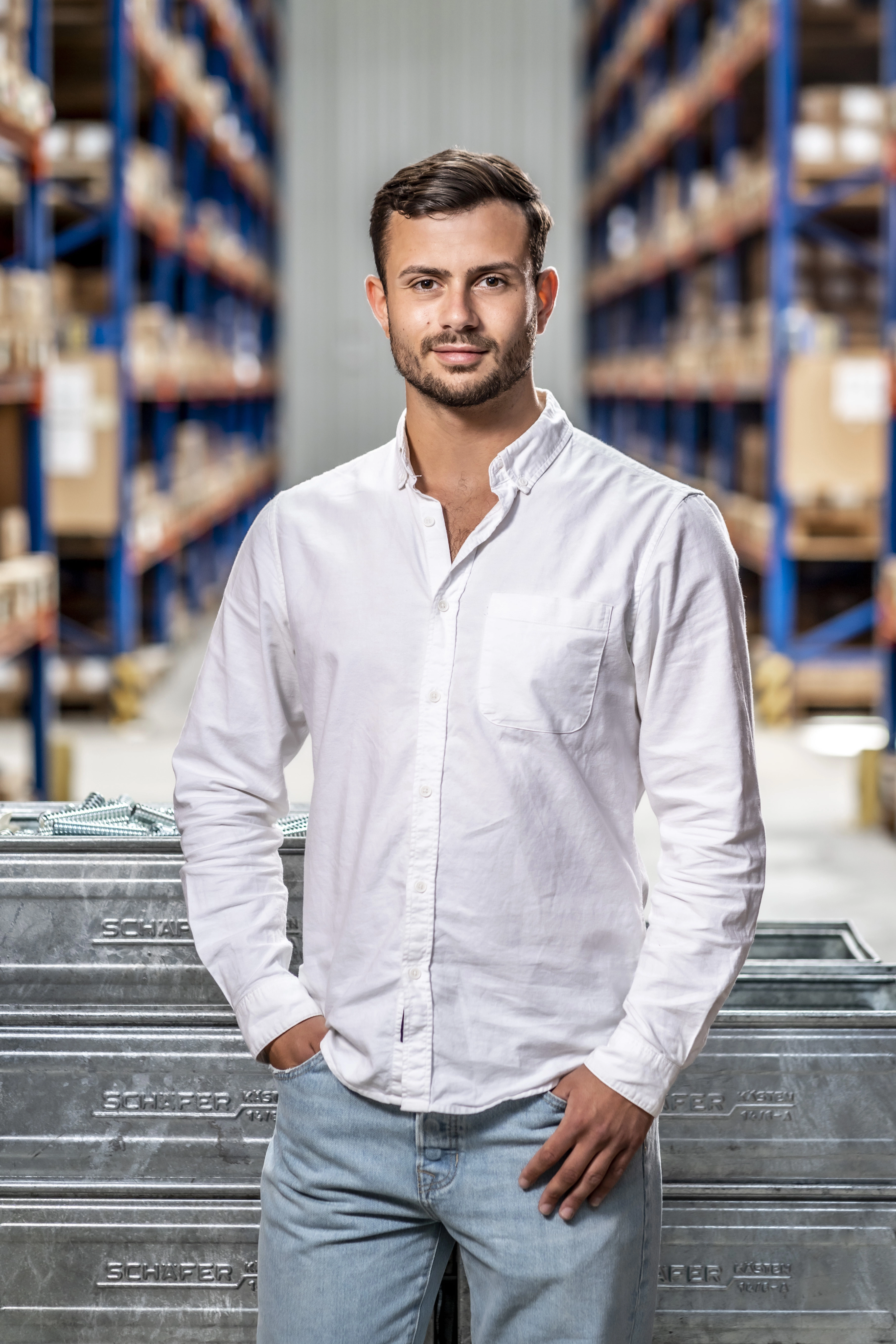 RAMPA's dual student stands in front of boxes filled with sleeves in the RAMPA warehouse.