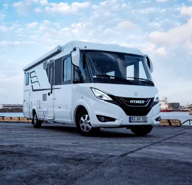 Hymer is a reference partner of RAMPA. A white motorhome from Hymer parked on concrete can be seen. In this vehicle, numerous RAMPA inserts have been used for the interior fittings.
